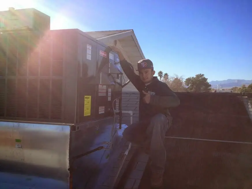 HVAC technician performing Heat Pump Repair on a rooftop unit in Haddam