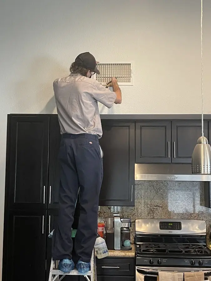 Technician inspecting an air vent during HVAC service in Haddam
